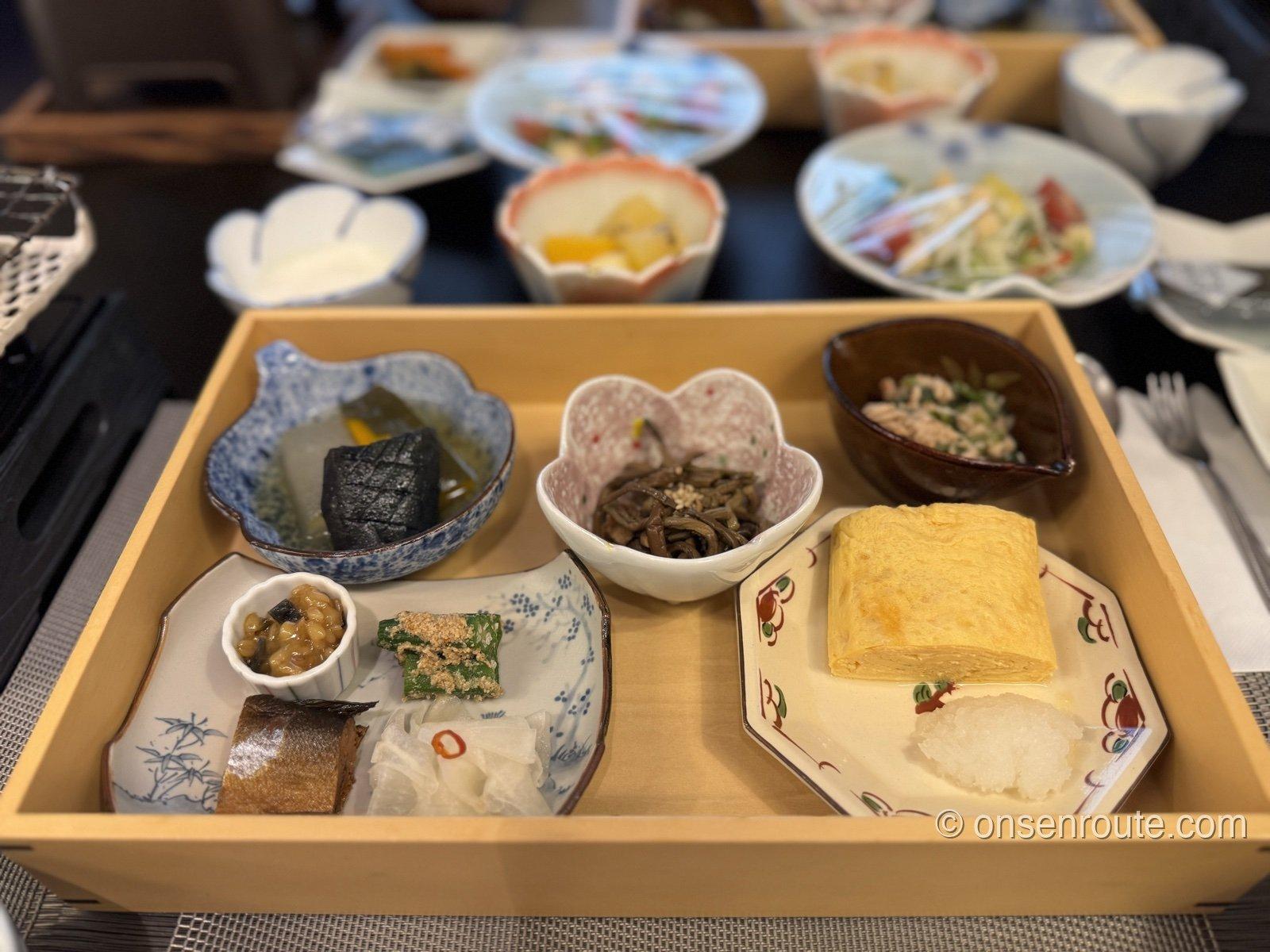 人吉旅館の朝食。木箱に小鉢と出汁巻き卵、焼き魚が並ぶ