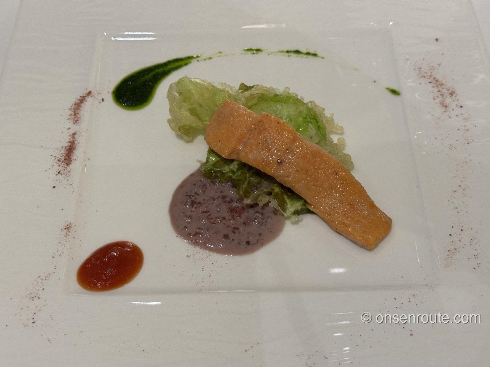 ホリホックのコースの魚料理。ソースとハーブオイルで彩られた白い角皿