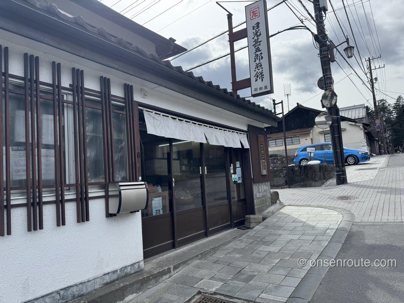 日光甚五郎煎餅の看板を掲げる石田屋の店構え。白い暖簾がかかる
