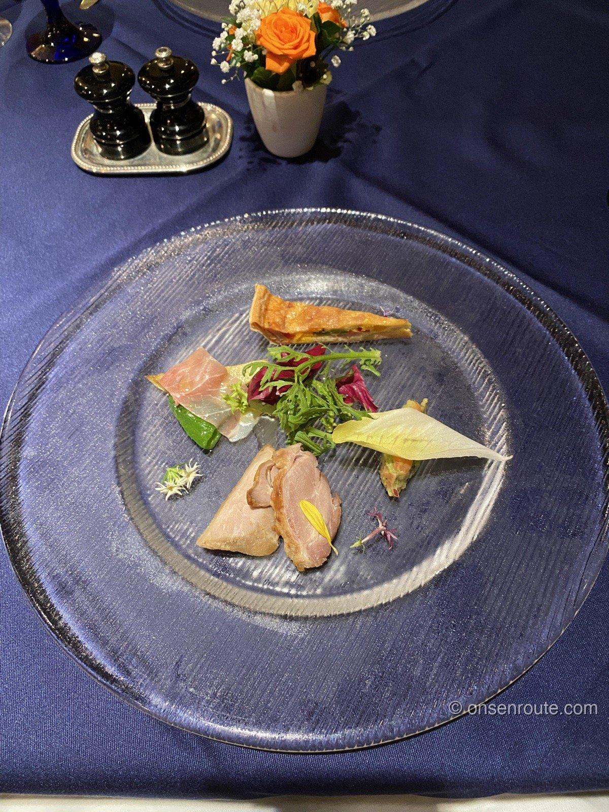 FONTANAの前菜。ガラスの大皿に生ハムやキッシュ、スモークした肉が彩りよく盛られる