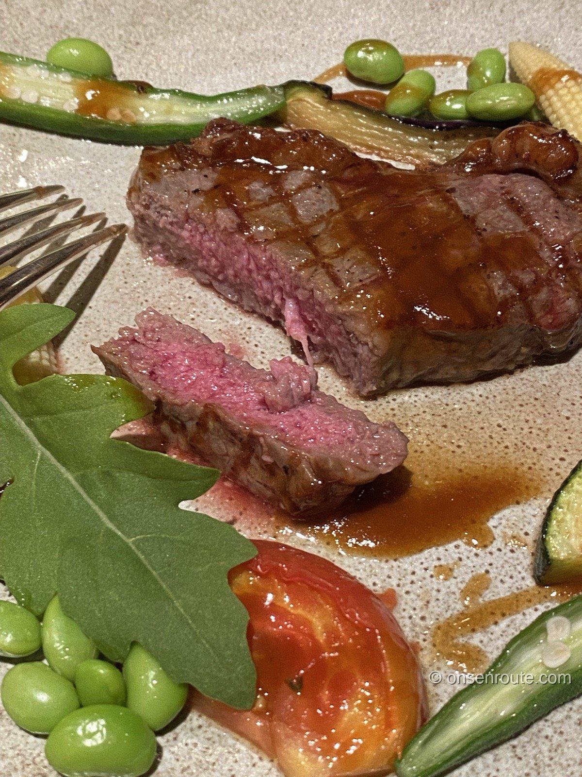 メインの牛肉のグリル。断面がロゼ色で、枝豆やオクラなど夏野菜が添えられる