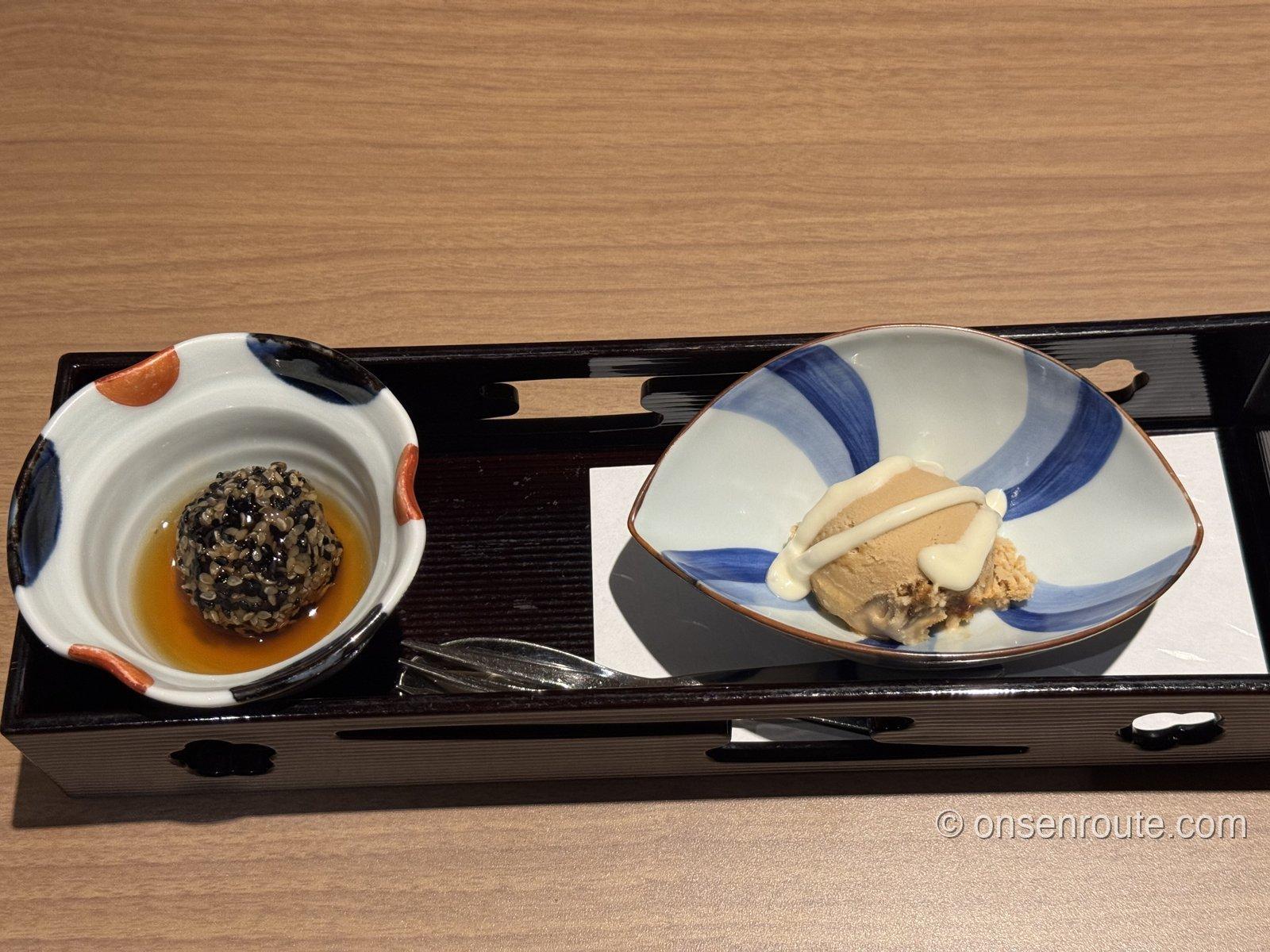 黒い長盆に載った甘味。左に胡麻をまとったごはん団子のべっ甲餡掛け、右に黒糖アイスのマスカルポーネ掛け