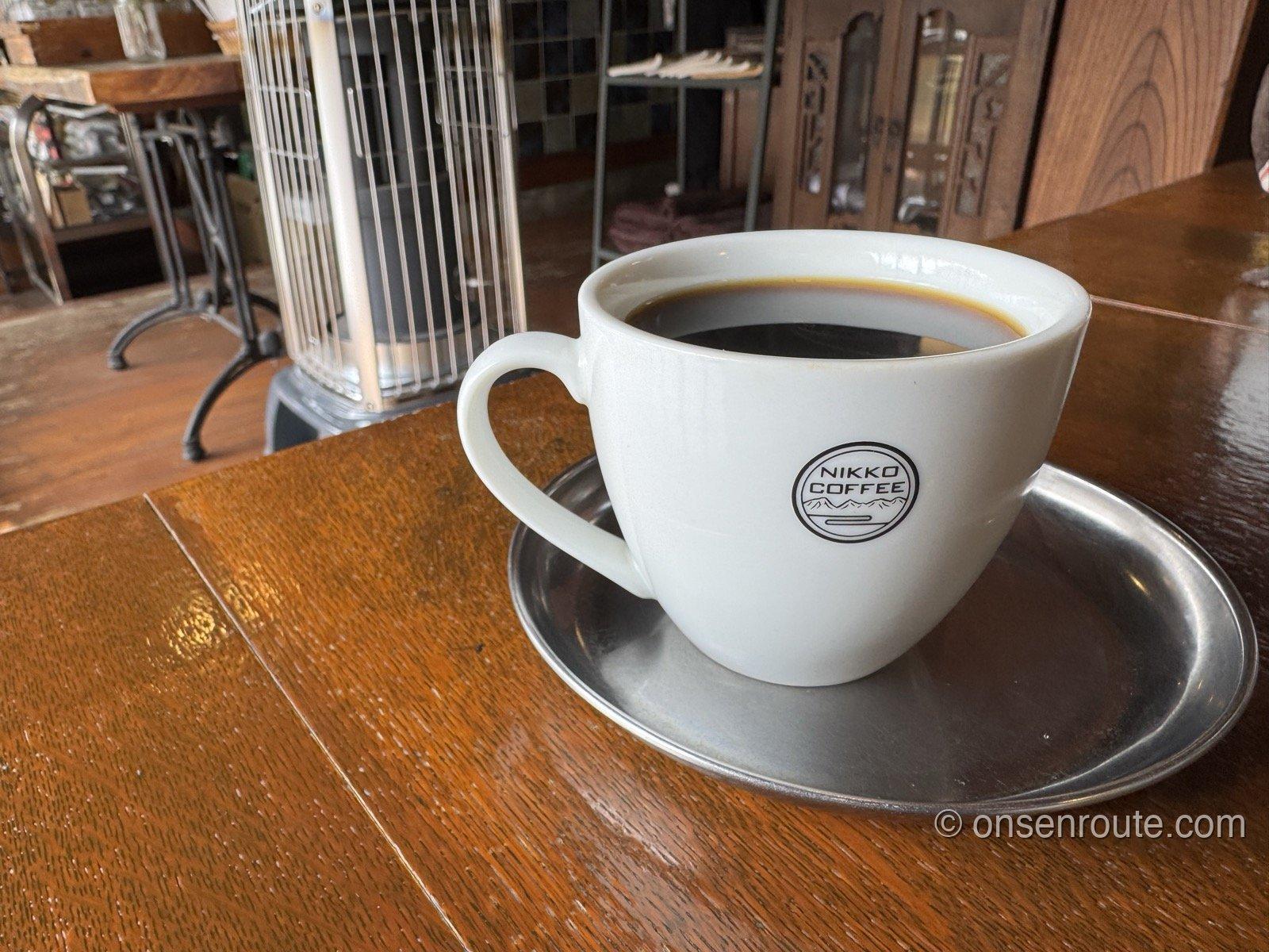 NIKKO COFFEEのロゴが入った白いカップに注がれた深煎りコーヒー