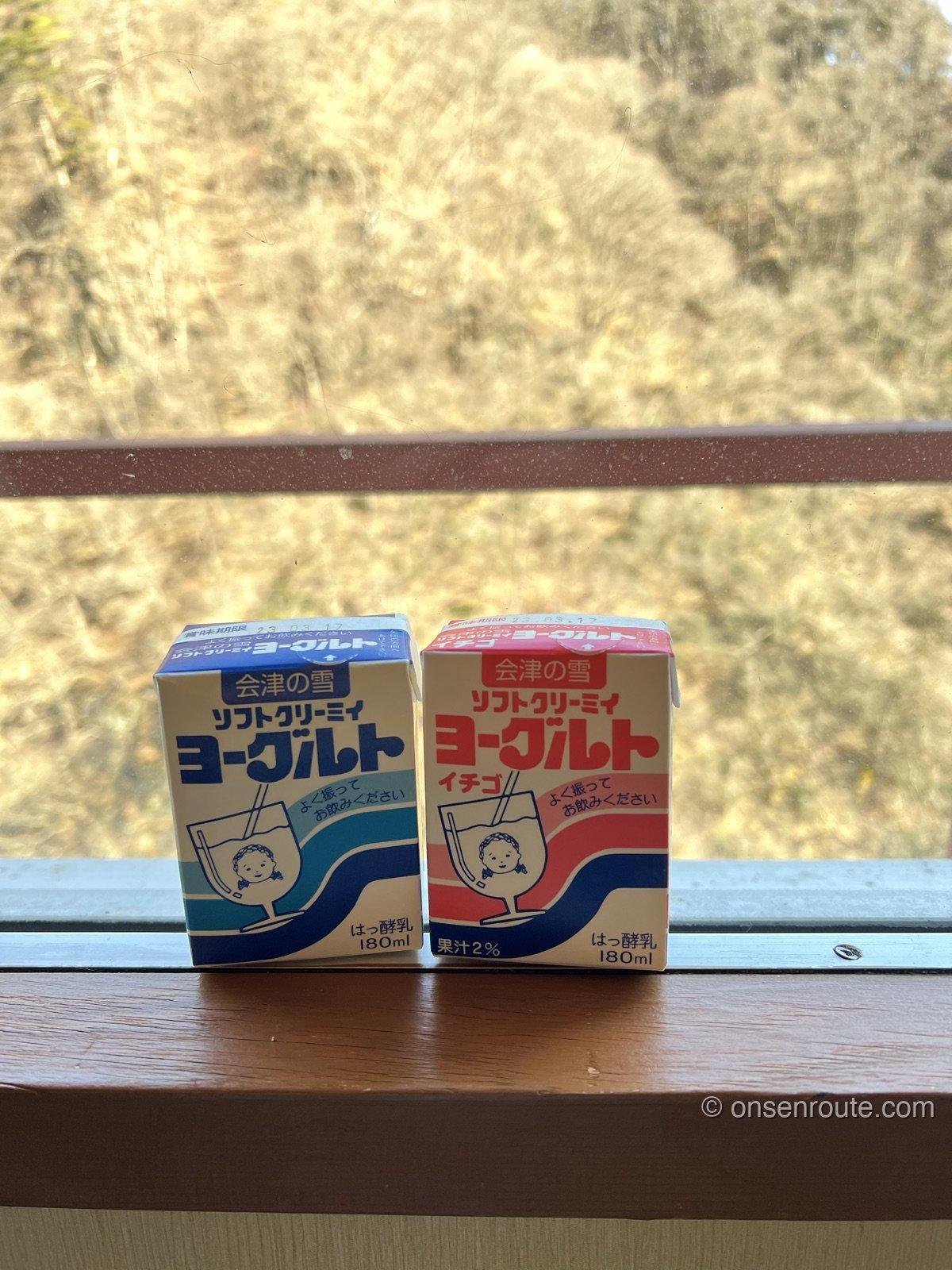 窓辺に置かれた会津の雪ヨーグルトの紙パック2つ。プレーンといちご味
