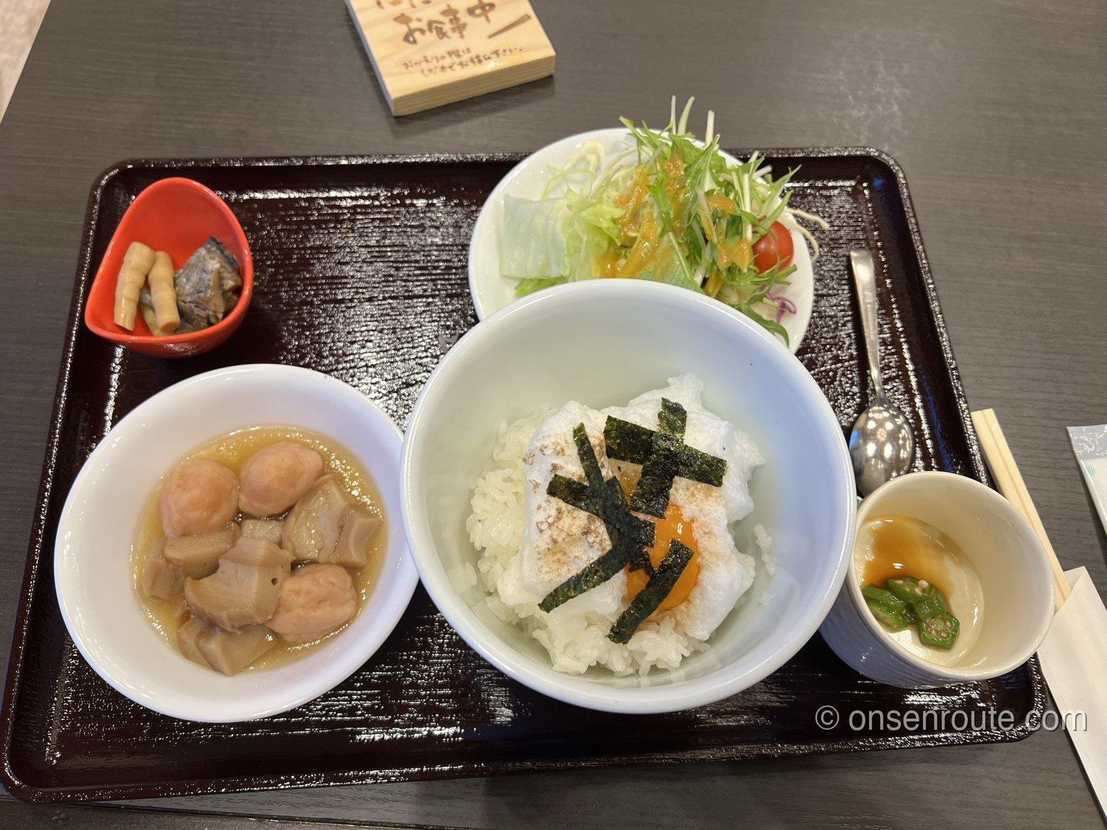 朝食のトレー。メレンゲと海苔がのった卵かけご飯、芋煮風の小鉢、サラダ、焼き魚が並ぶ