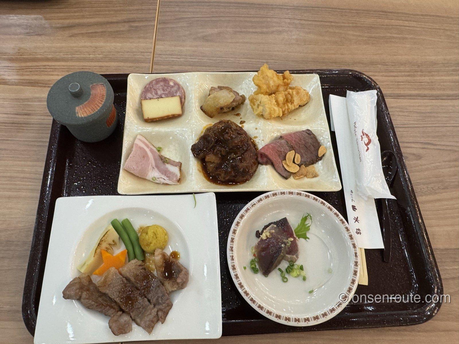 ゆふいん山水館の夕食バイキングのトレー。スモークチーズ、サラミ、とり天、煮込み、ローストビーフの盛り合わせと鉄板ステーキ、カツオのたたきの小鉢