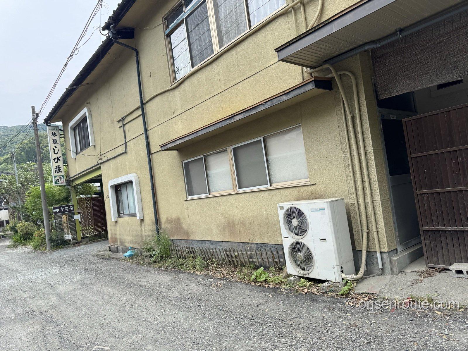 旅籠しび荘の外観。2階建ての建物と看板