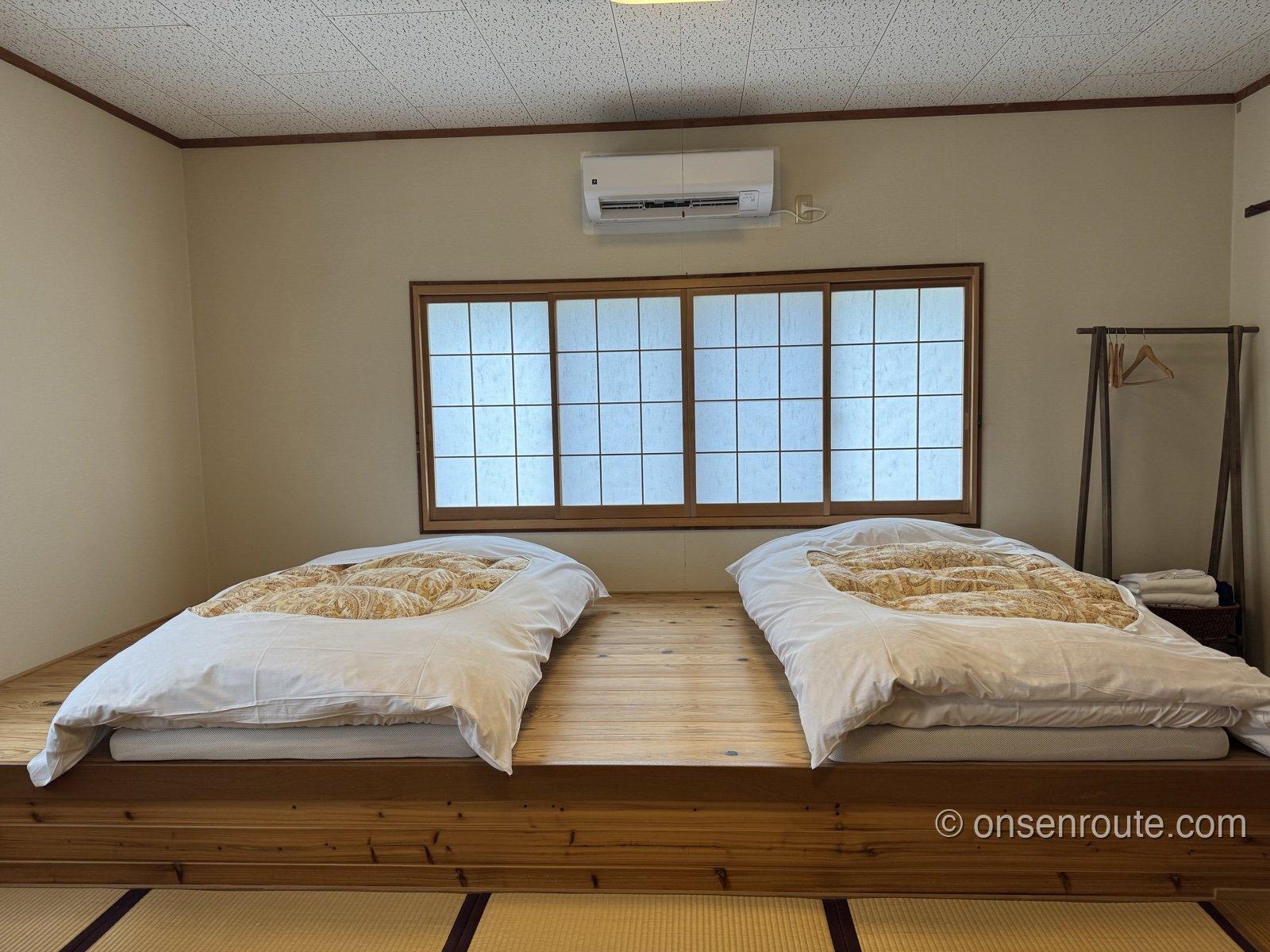 旅籠しび荘のおまかせ和室。障子窓の前に布団が2組敷かれている