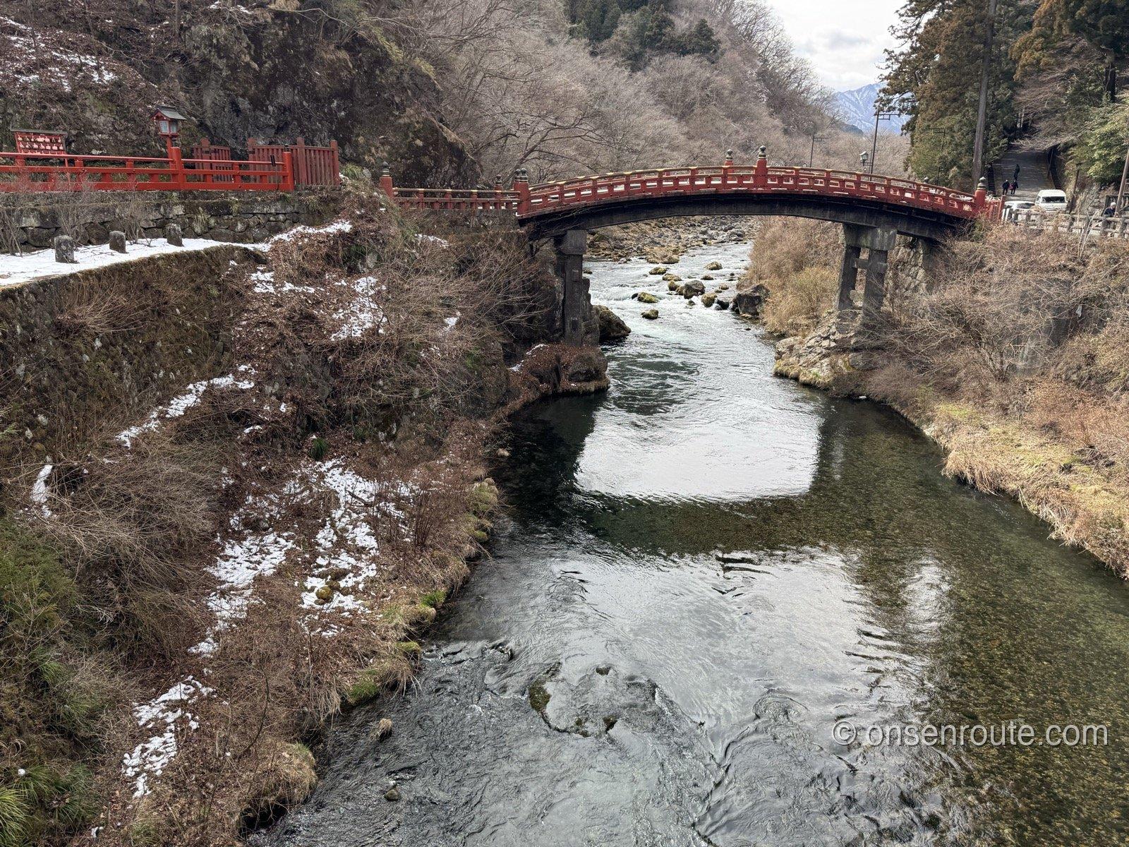 大谷川に架かる朱塗りの神橋。岸には雪が残り、渓流の水が澄んでいる