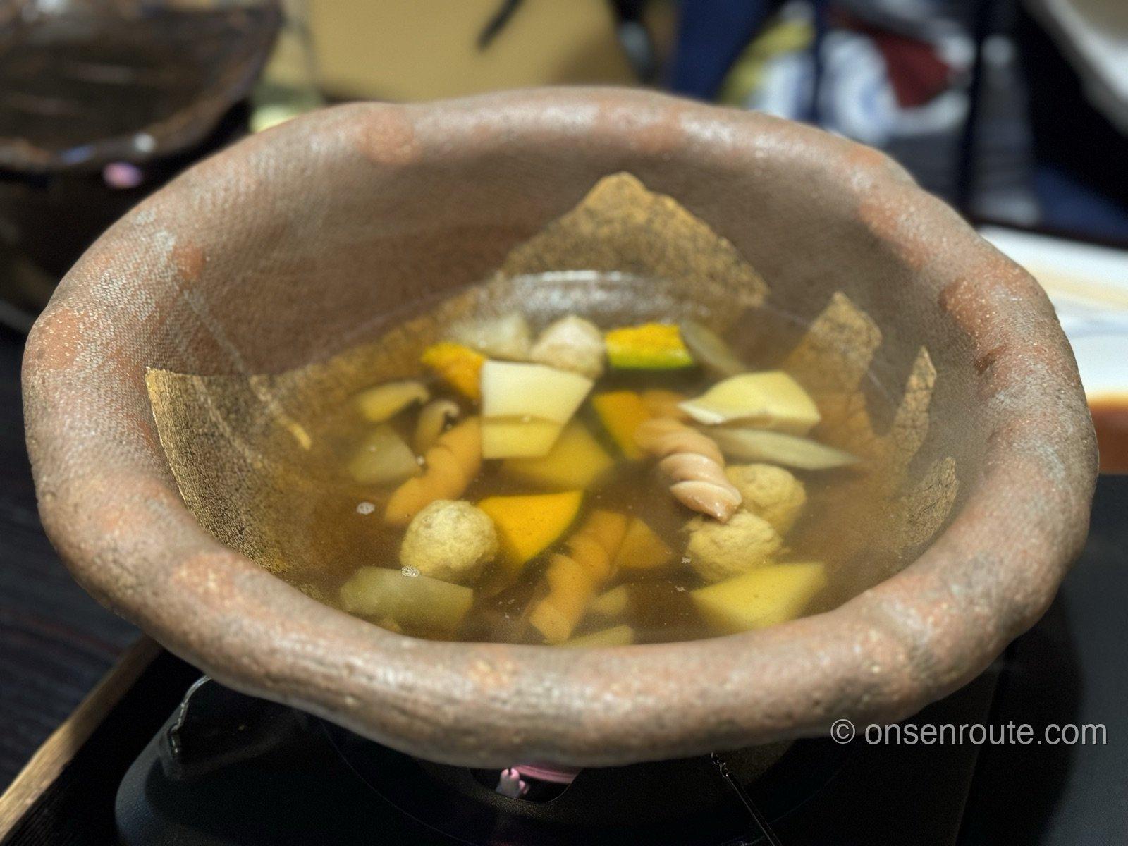 素焼きの土鍋に入った団子汁。かぼちゃや芋、団子が出汁に浮かぶ