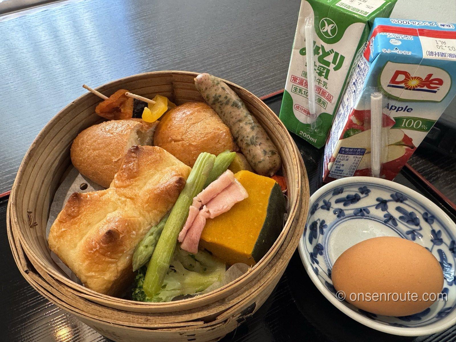 洋風のせいろ朝食。パン、ソーセージ、ベーコン、かぼちゃ、アスパラにゆで卵と牛乳が付く