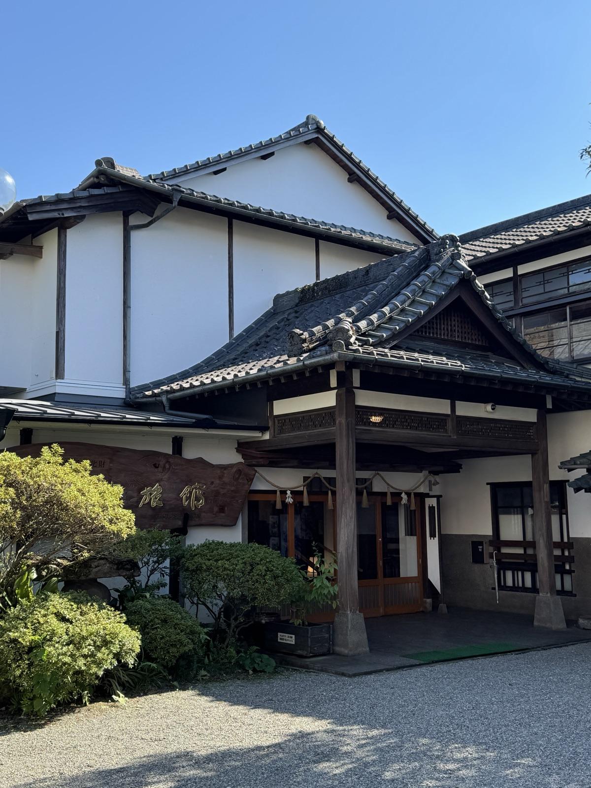人吉旅館の玄関。瓦屋根の唐破風の車寄せに、しめ縄が下がっている