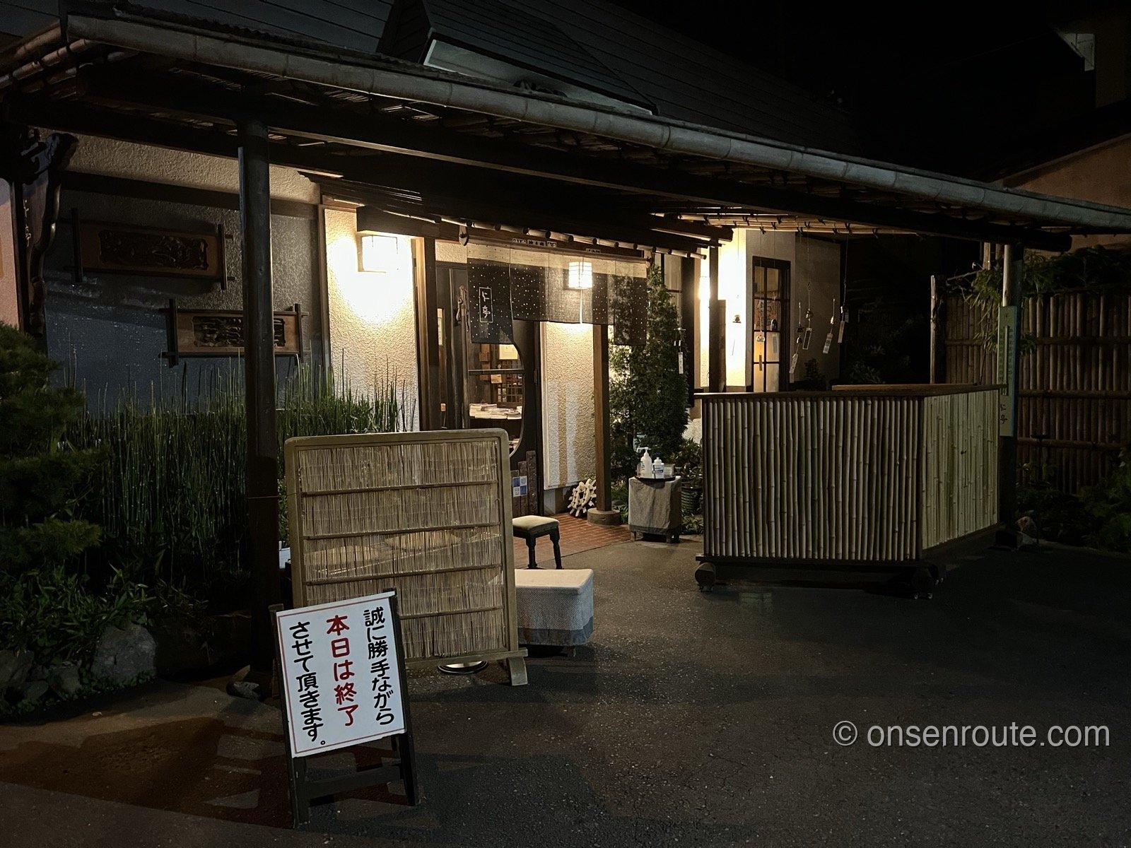 夜の仁亭の店先 「本日は終了させて頂きます」の看板が出ている