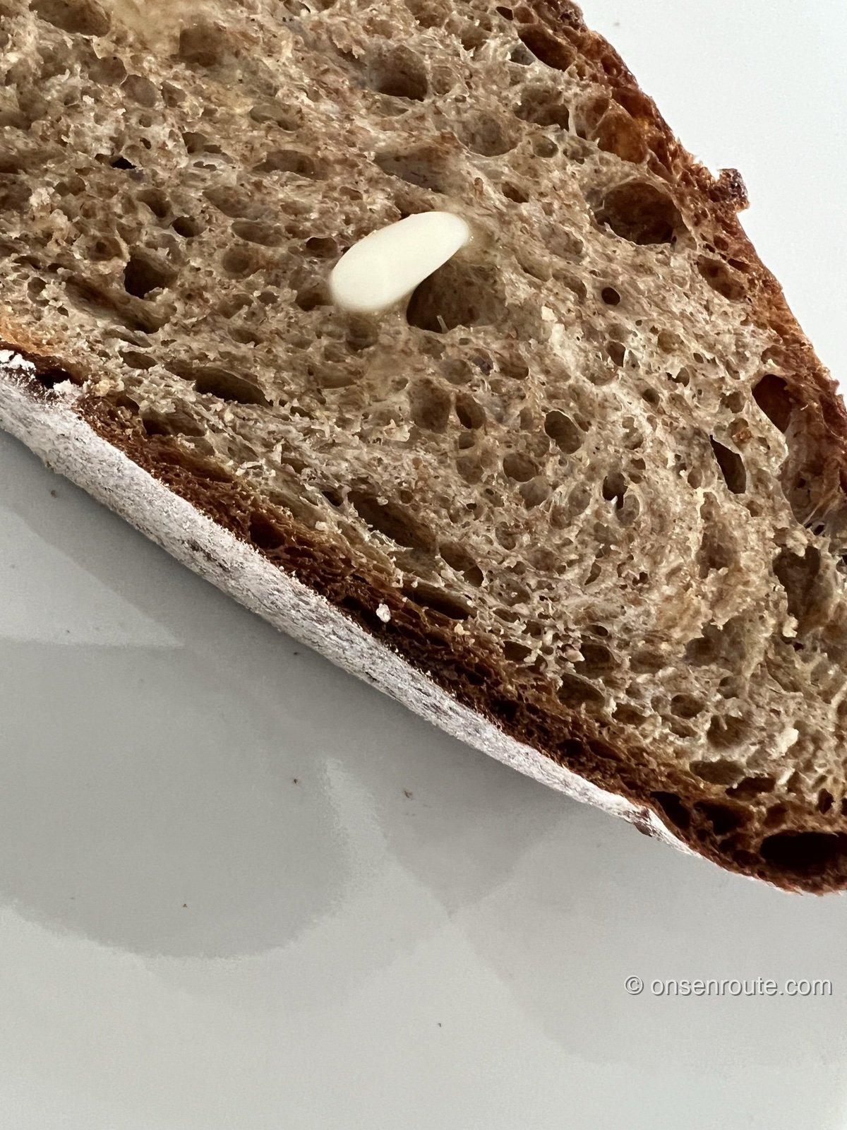 エグ・ヴィヴのハード系パンのスライスにバターを載せたところ。気泡の入ったしっとりした断面