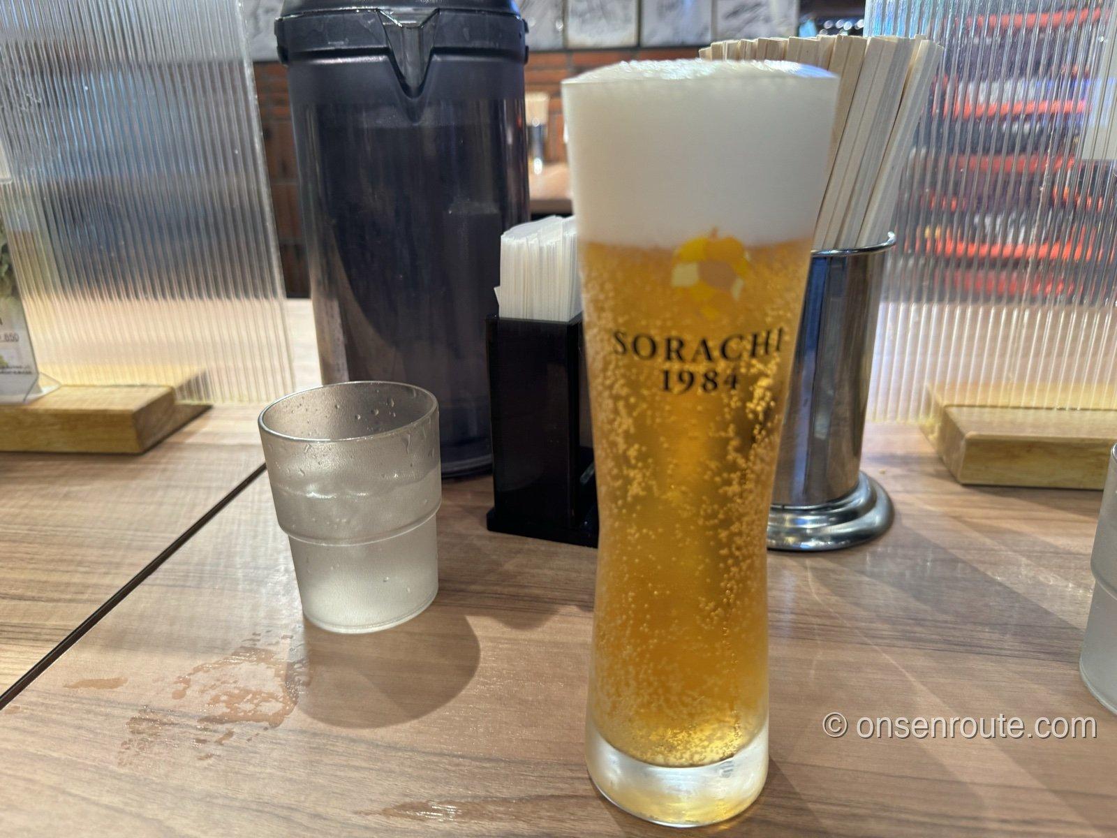 SORACHI 1984の生ビール。ロゴ入りグラスに注がれ、きめ細かい泡が立つ
