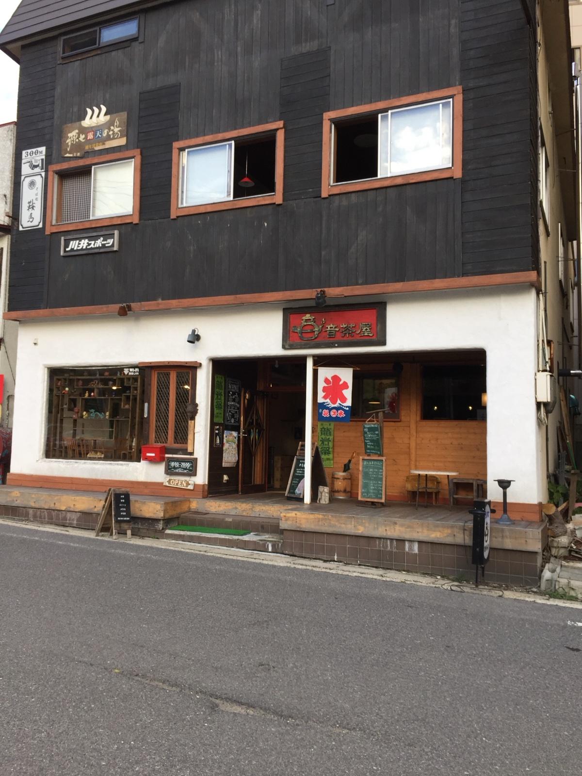 蔵王温泉の温泉街に建つ音茶屋の外観。黒い板壁の建物に赤い氷の旗が出ている