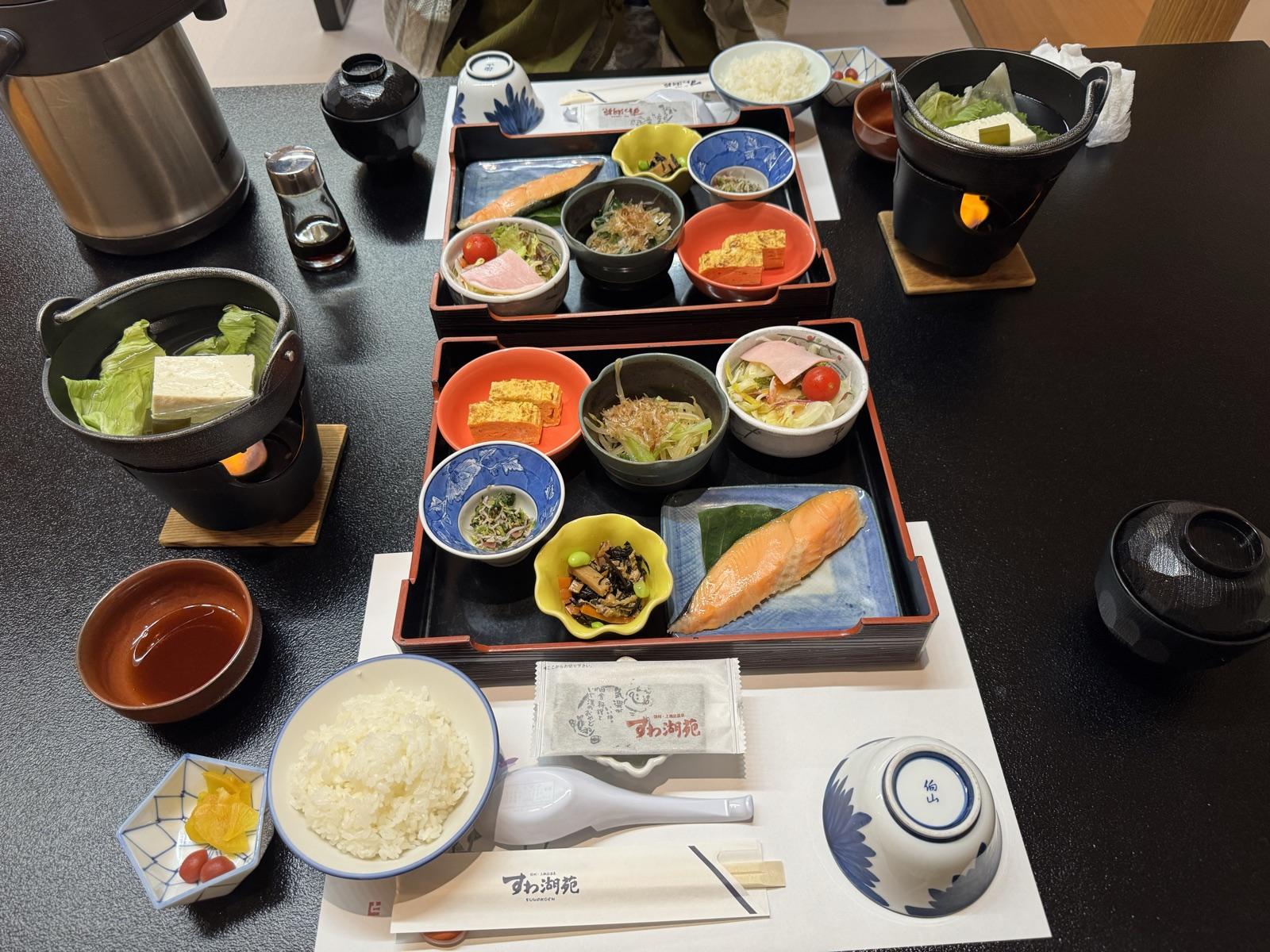 すわ湖苑の朝食。二段の重箱に焼き鮭・出汁巻き卵・小鉢が並び、固形燃料の湯豆腐、ご飯と味噌汁
