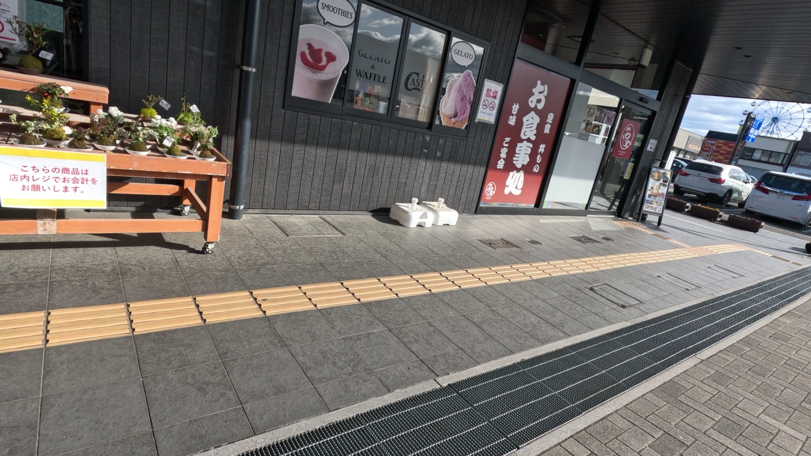 道の駅日光 日光街道ニコニコ本陣の入口。お食事処の看板とジェラート店の窓、店頭の鉢植えが並ぶ