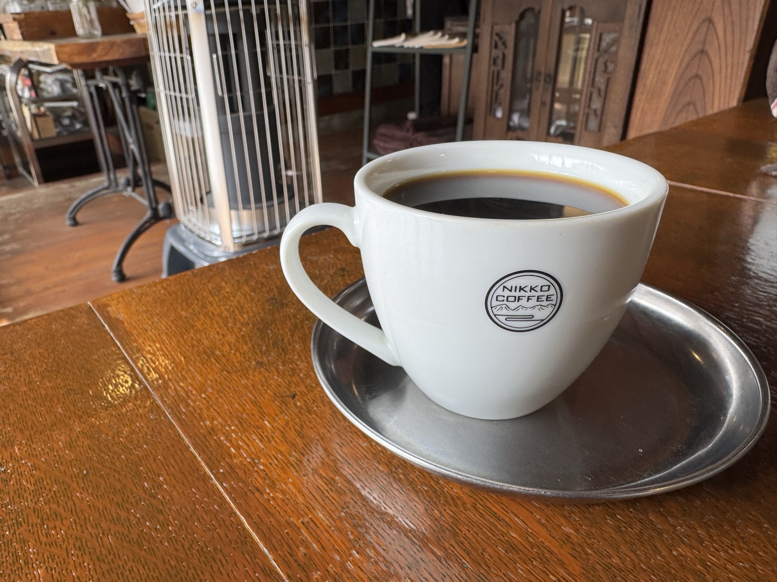 NIKKO COFFEEのロゴが入った白いカップに注がれた深煎りコーヒー